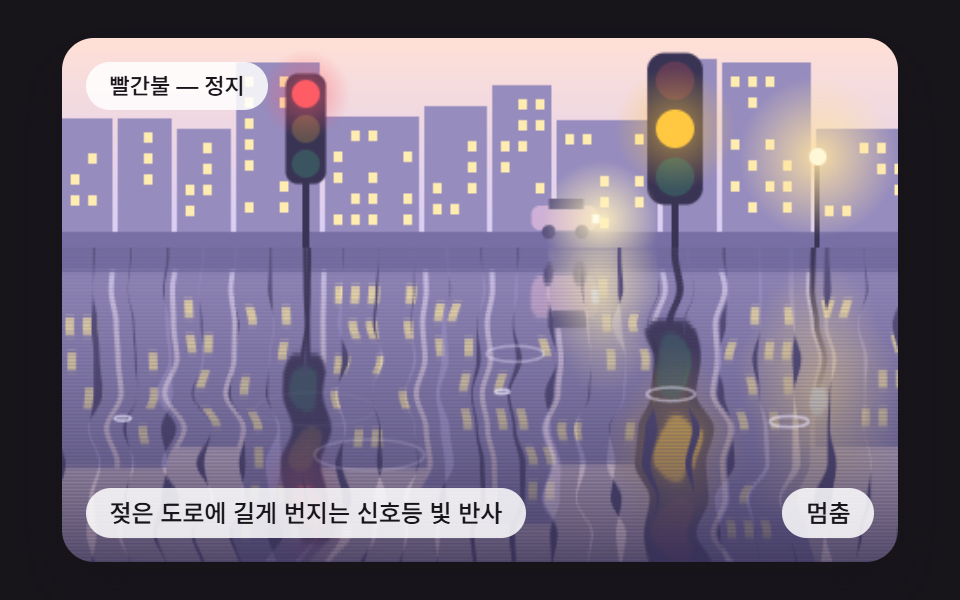 젖은 도로에 길게 번지는 신호등 빛 반사